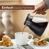 A hand is pouring coffee from a carafe into a white mug, with croissants and pastries on a table. Produktbild-Vorschau