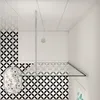 A top-down view of a modern bathroom shower enclosure with black and white patterned tiles. Produktbild-Vorschau