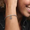A close-up shot of a woman's wrist wearing a Pandora bracelet with a Hamsa hand charm. Anteprima dell’immagine prodotto
