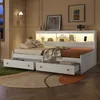 A bedroom scene featuring a white daybed with drawers and a headboard with integrated lighting and shelves. Voir les images du produit