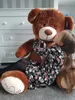 A young girl is hugging and kissing a very large teddy bear. Podgląd zdjęcia produktu