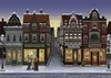 A charming, snow-covered street scene with traditional European-style buildings adorned with Christmas lights and decorations. Several shops are visible, including a bakery, a tailor, and a bookstore. Three people are standing in the street, seemingly inte Produktbild-Vorschau