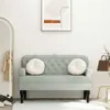 A light gray velvet bench with tufted detailing and two round white cushions is shown in a room with a mirror and a framed picture on the wall. Náhled obrázku produktu
