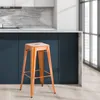 An orange metal bar stool is shown in a kitchen setting. Náhľad obrázku produktu
