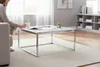 A person is sitting on a couch, holding a mug, next to a coffee table in a living room. Produktbild-Vorschau