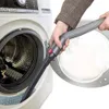 A person is using a vacuum cleaner attachment to clean inside a washing machine. Produktbild-Vorschau