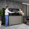 A couple is putting cushions into a large outdoor storage box on a wooden deck. Náhľad obrázku produktu