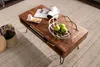 A wooden coffee table with a decorative bowl of apples and magazines on it, placed on a rug. Náhled obrázku produktu