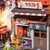 A miniature diorama of a Japanese alleyway shop selling wine. Voir les images du produit