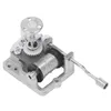 A close-up view of a music box mechanism with a hand crank. Voir les images du produit