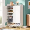 A white shoe cabinet with multiple shelves filled with shoes and slippers, placed in a room with teal walls. Náhľad obrázku produktu