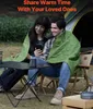 A couple is sitting outdoors sharing a blanket and looking at a phone. Anteprima dell’immagine prodotto