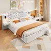 A bedroom scene featuring a white bed with orange accents, bedside tables, and decorative elements. Voir les images du produit