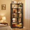 A corner bookshelf filled with decorative items and books, placed in a room with a lamp and a bed. Produktbild-Vorschau