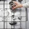 A hand places a metal coffee maker component into a dishwasher rack. Náhľad obrázku produktu