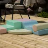Soft play blocks arranged on a wooden deck outdoors. Produktbild-Vorschau