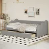 A gray daybed with a pull-out drawer is set up in a room with artwork on the wall and a patterned rug. Produktbild-Vorschau