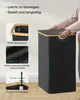 A person's hands are shown closing the lid of a black laundry basket with a wooden rim and lid. Produktbild-Vorschau