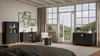 A bedroom with a large window overlooking a lake and trees. Furniture is arranged in the room. Produktbild-Vorschau