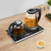 A tea set with two glass kettles on an induction cooktop, placed on a wooden countertop. Podgląd zdjęcia produktu