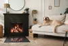 A golden retriever dog lies on a sofa next to a fireplace in a living room. Produktbild-Vorschau