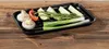 A black grilling tray filled with various vegetables and herbs, placed on a wooden surface. Produktbild-Vorschau