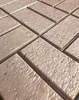 A close-up, angled view of textured, rectangular tiles arranged in a grid pattern. Produktbild-Vorschau