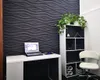 A modern office or workspace setup with a desk, laptop, chair, and shelving unit against a textured wall. Podgląd zdjęcia produktu