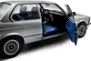 A close-up, studio shot of a silver BMW 323I E21 model car with the driver's side door open, revealing the blue interior. Anteprima dell’immagine prodotto