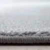 A close-up, side view of the edge of a gray carpet. Produktbild-Vorschau