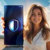 A woman is holding a smartphone with a shield icon on the screen, with a beach and sky in the background. Anteprima dell’immagine prodotto
