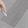 A hand is shown cutting a piece of vinyl flooring with a utility knife. Produktbild-Vorschau
