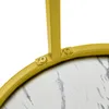 A close-up view of the connection between a gold metal frame and a marble-patterned surface, secured by screws. Náhled obrázku produktu