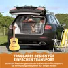 A dog in a crate inside the trunk of a car, with a guitar and a beach chair nearby. Produktbild-Vorschau