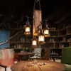 A rustic chandelier hangs above a wooden table in a room with bookshelves. Náhled obrázku produktu