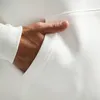 A close-up shot of a person's hand in the pocket of a white hoodie. Produktbild-Vorschau
