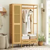 A wooden wardrobe stand with clothes hanging on it, placed in a room with a basket and flowers. Podgląd zdjęcia produktu