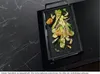 A grill pan filled with grilled vegetables sits on a black induction cooktop. Podgląd zdjęcia produktu