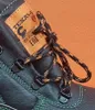 A close-up view of the lacing area of a black work boot, showing the lacing system and a brand label. Náhľad obrázku produktu
