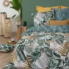 A bedroom scene with a bed dressed in tropical-themed bedding, decorative lanterns, and a plant. Produktbild-Vorschau