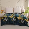 A blanket with a butterfly pattern is laid out on a bed with white pillows. Produktbild-Vorschau