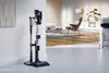 A cordless vacuum cleaner is shown docked on its charging station in a modern living room setting. Náhľad obrázku produktu