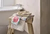 Towels are folded on a wooden stool next to a bathtub. Produktbild-Vorschau