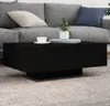 A black coffee table with a white cup and saucer and a potted plant on top, placed in front of a gray sofa on a carpeted floor. Produktbild-Vorschau