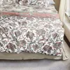 A close-up view of a bed with patterned bedding. Produktbild-Vorschau