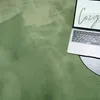 A laptop is placed on a soft, green rug. Náhled obrázku produktu