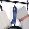 A close-up view of a frying pan handle and two pot holders hanging from a rack. Produktbild-Vorschau