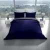 A bed with blue and anthracite bedding is set up in a modern room with large windows overlooking a landscape. Produktbild-Vorschau