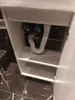The underside of a white bathroom cabinet with plumbing visible. Podgląd zdjęcia produktu