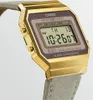 A close-up, angled shot of a gold-colored digital watch with a fabric strap, displayed against a white background. Voir les images du produit